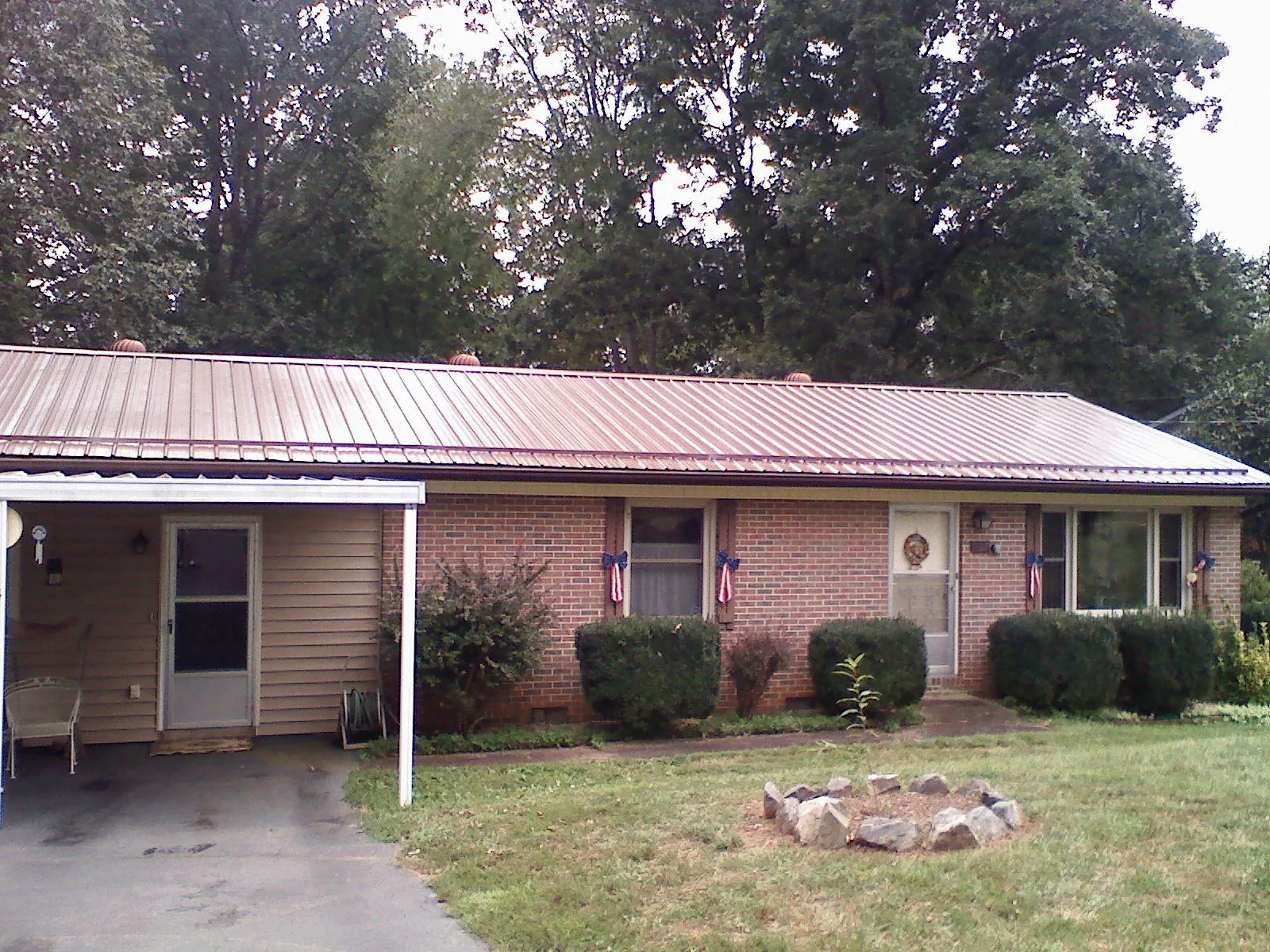Bronze metal roof and carport on a brick ranch home — Roof Repair work by our crew in Inwood