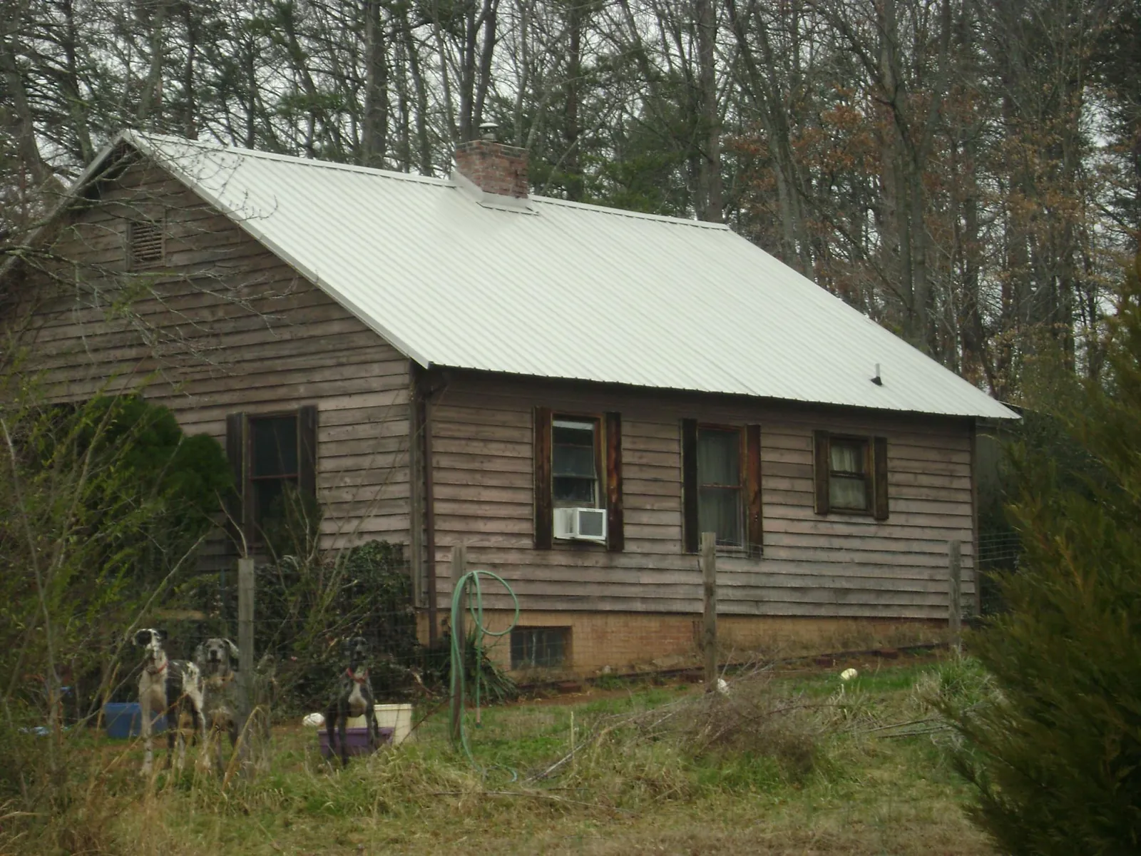 White metal roof on an old wood sided farmhouse, from a Metal Roof Installation job in Inwood